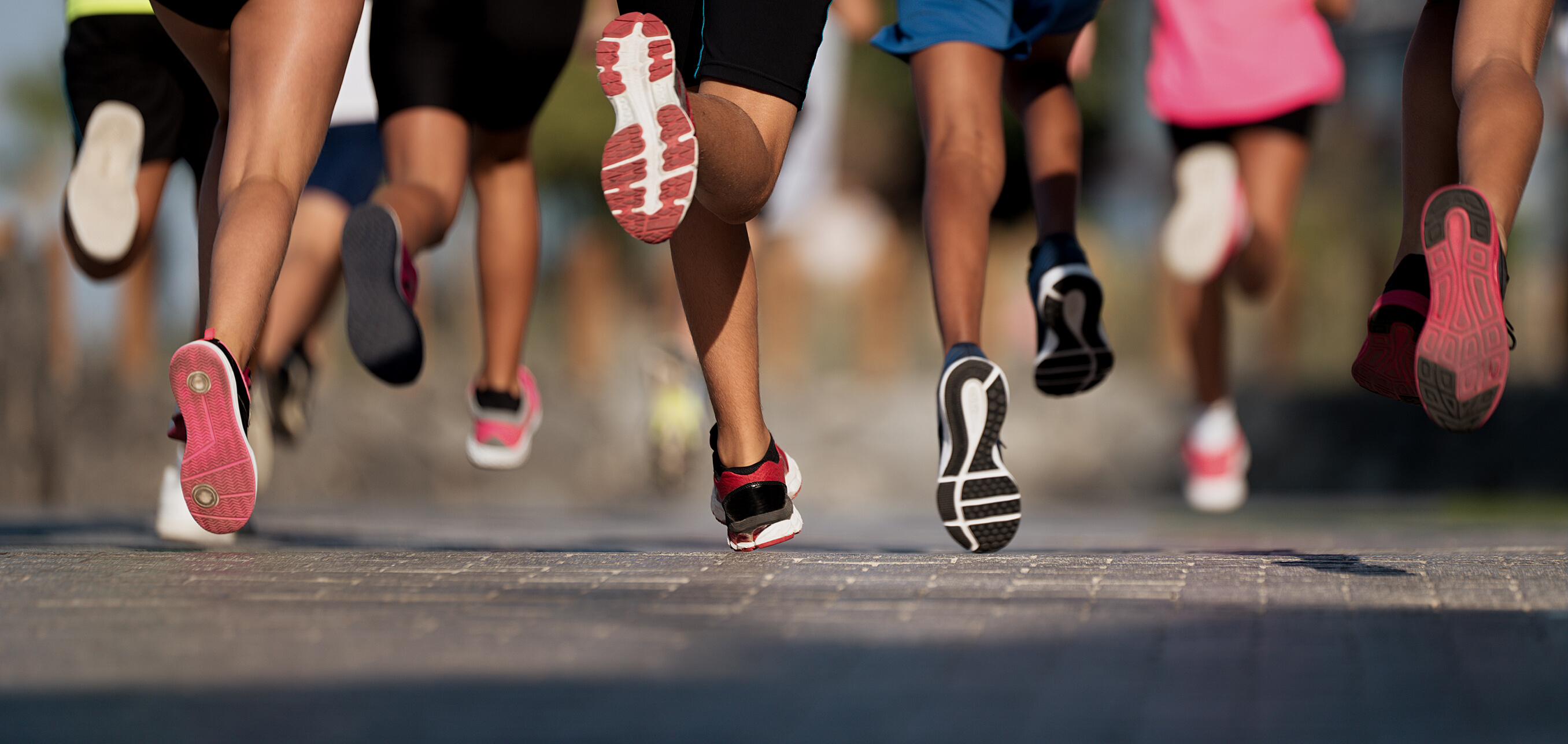 Running children, young athletes run in a kids run race,running on city road detail on legs